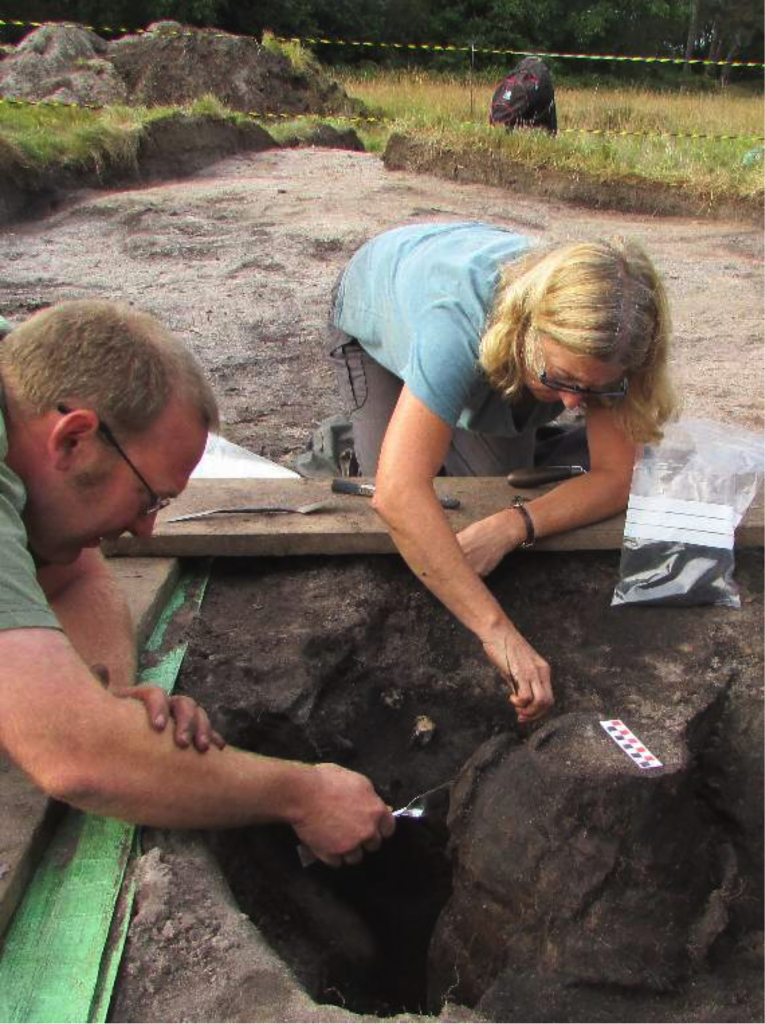 Dig director George Anelay (left) and volunteer Jane King uncover the burial urn